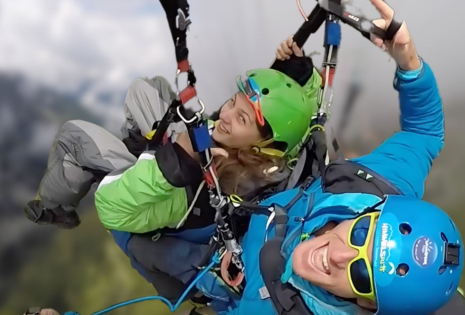 Eine froehliche Mitfliegerin beim Gleitschirm Tandemflug